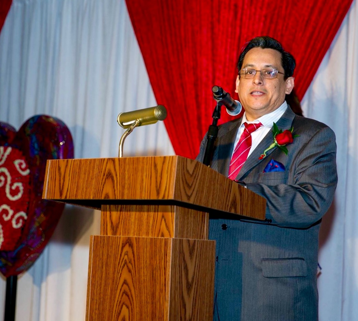 Santiago Mendoza, Jr. speaking at a podium during a community gala