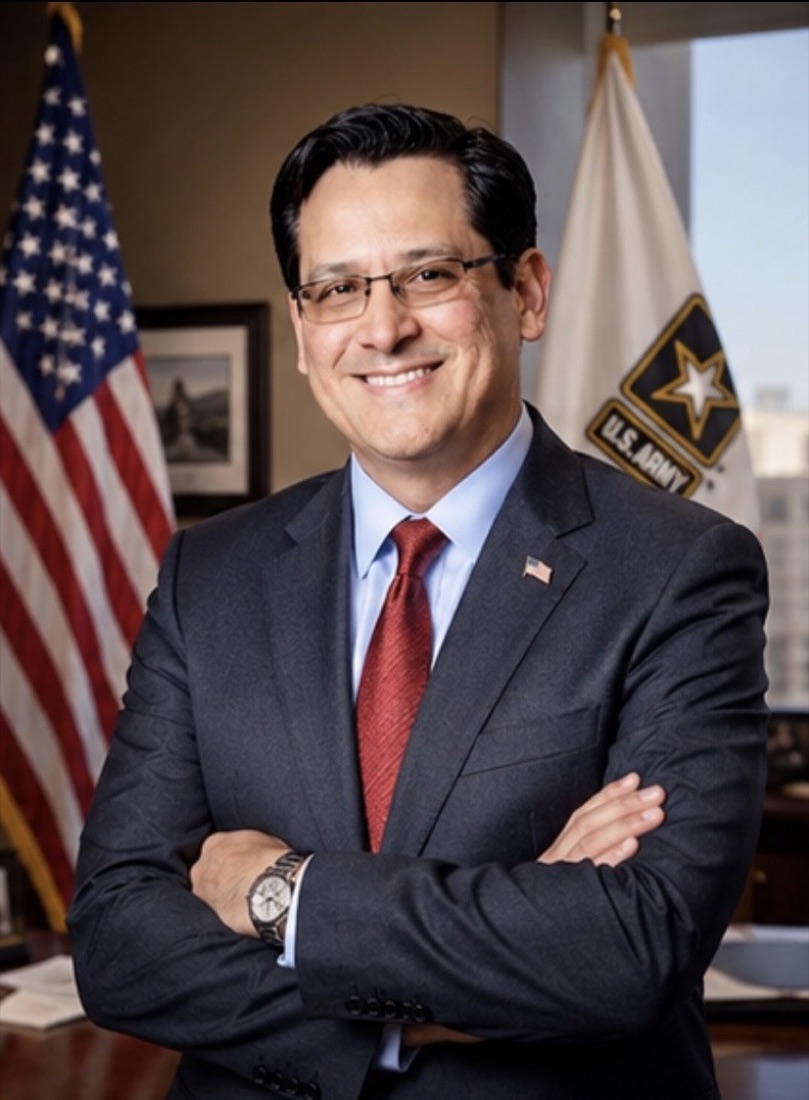 Santiago Mendoza, Jr., U.S. Army veteran and Founder of Teleioo Group, standing with arms crossed in front of the United States and U.S. Army flags